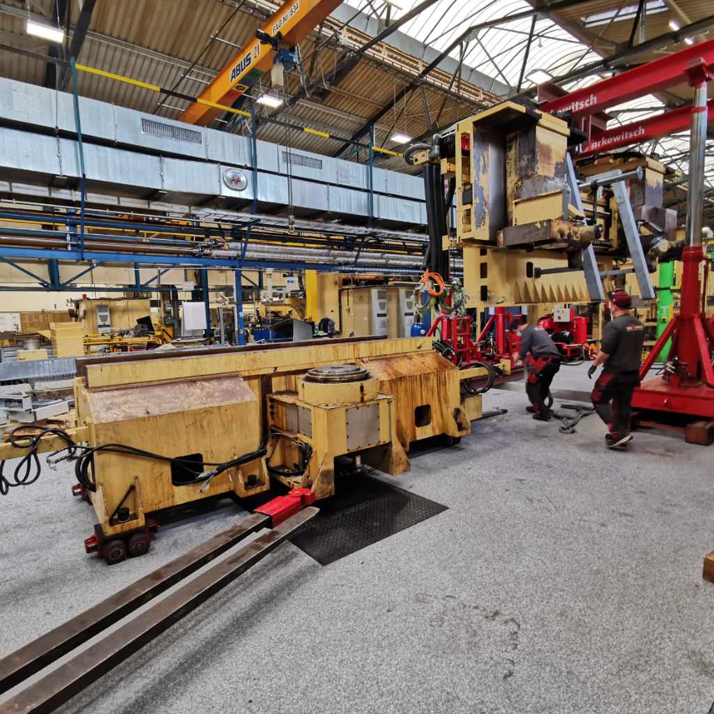 Große gelbe Maschine bei der Demontage in einer Produktionshalle